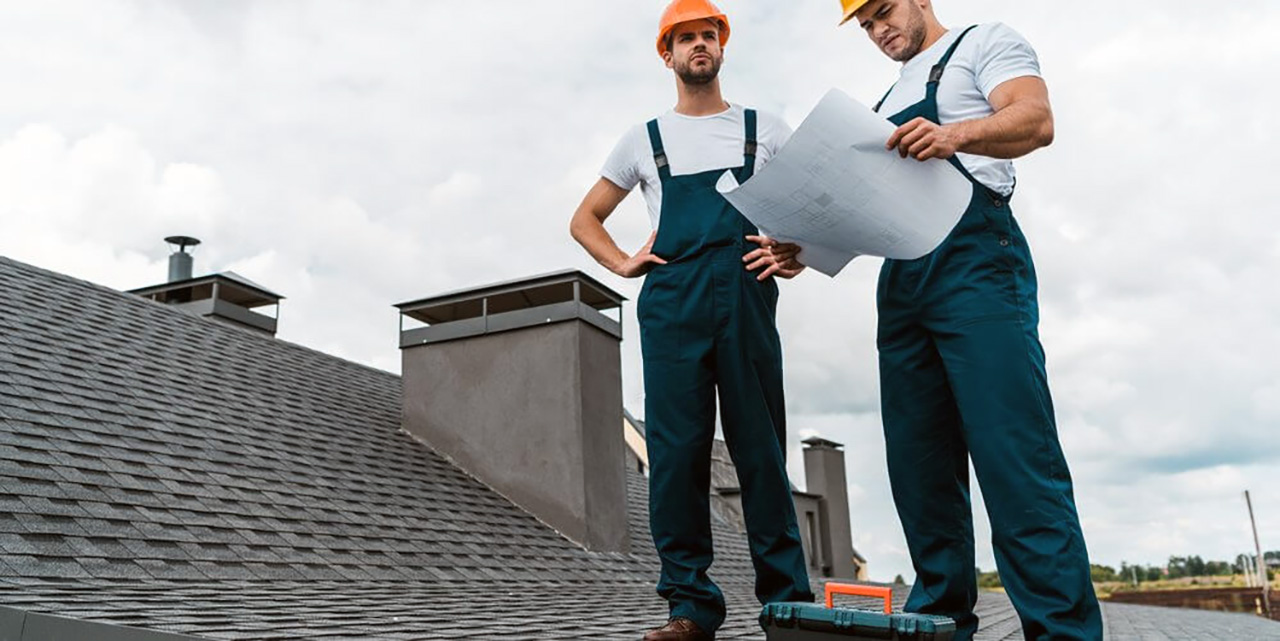 workers on roof with blueprint