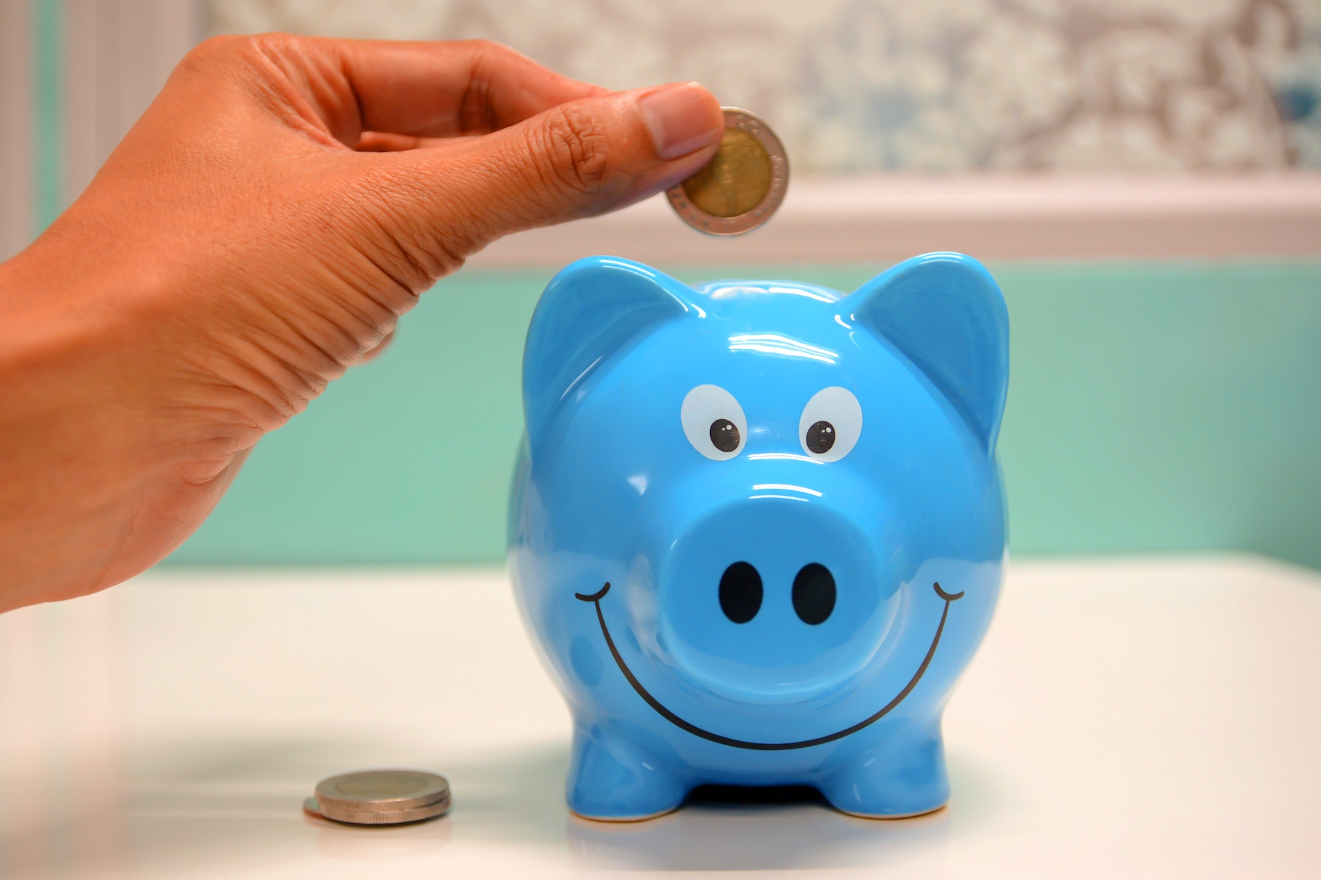 person putting money in piggy bank